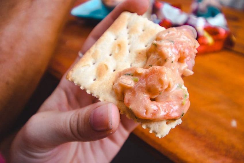 A hand holding a slice of bread with a spread. 3