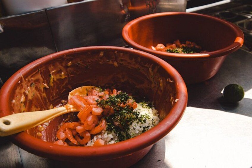 Two terracotta bowls with food ingredients on a kitchen counter. 2