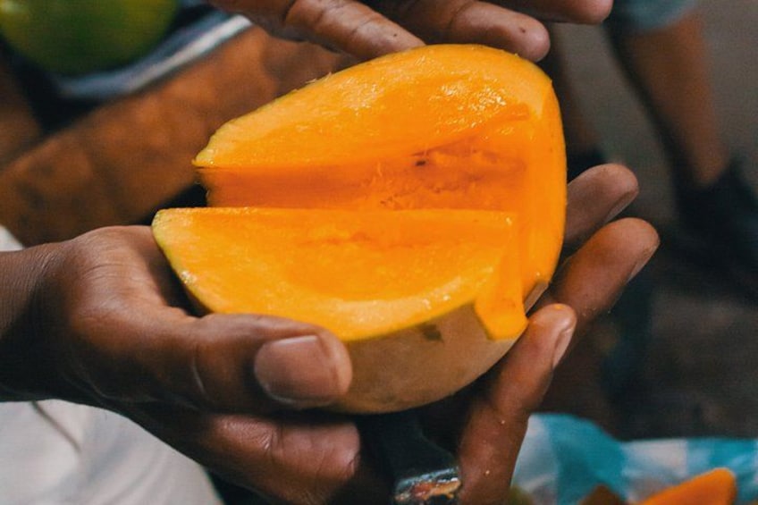 A person holding a halved orange fruit. 2