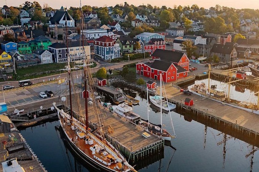 A harbor with a large ship docked, colorful buildings, and a red house. 1