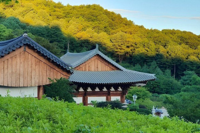 Traditional Korean architecture with wooden buildings and a mountainous backdrop. 3