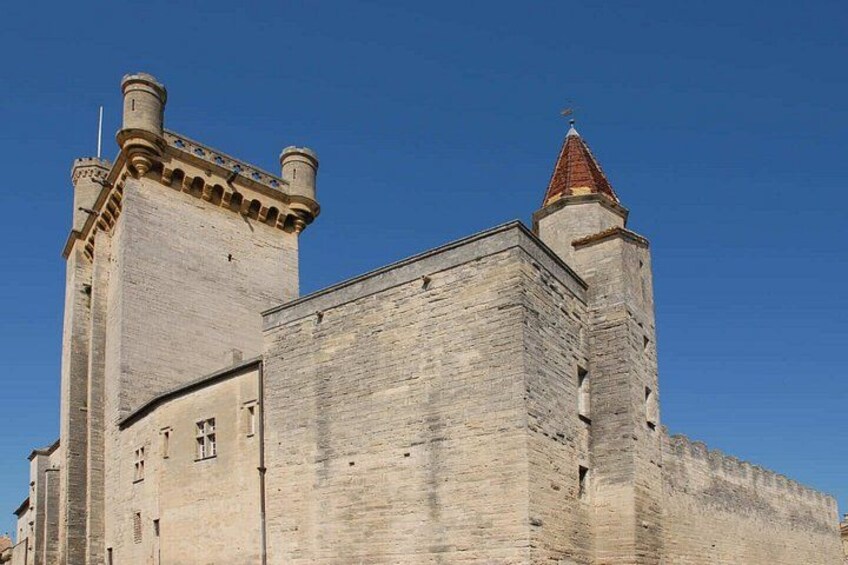 A large stone castle with two prominent towers and a red-tiled roof. 4