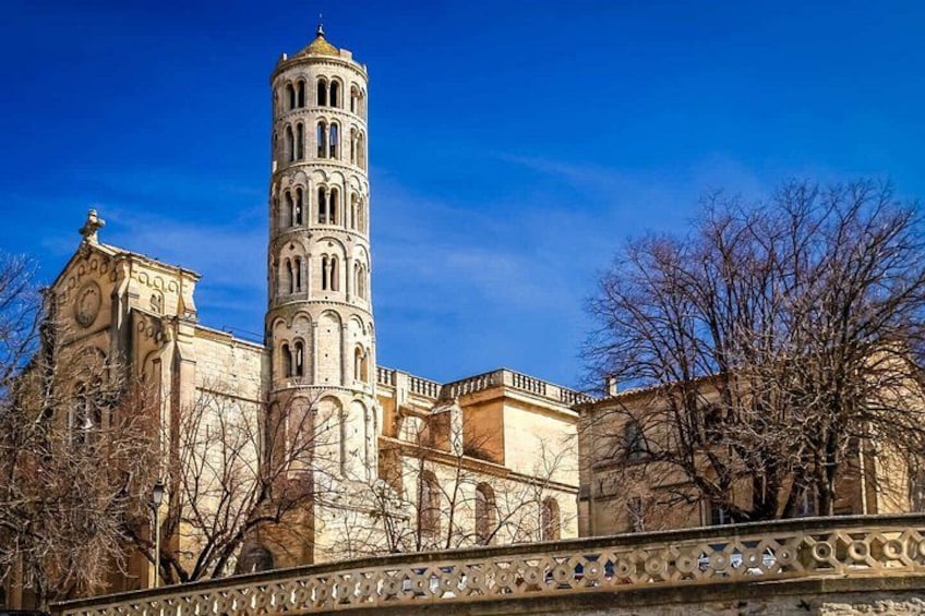 A historic building with a tall bell tower, a clock tower, and a decorative fence. 3