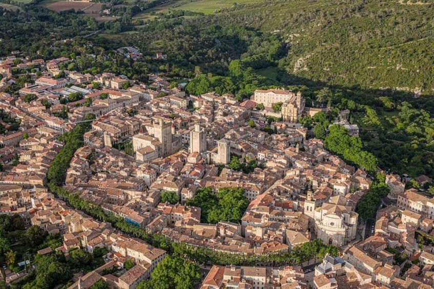 A historic town with a central church, surrounded by dense residential buildings and lush greenery. 2