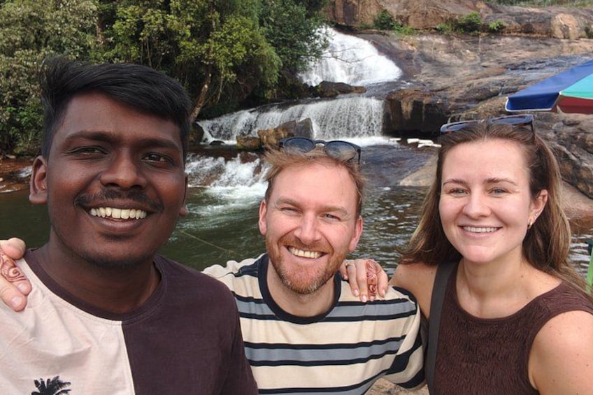 Three people standing in front of a waterfall. 4