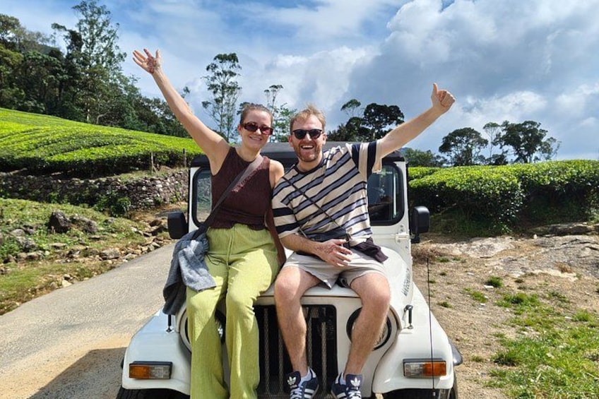 Two people on a vehicle in a rural setting with green fields and a clear sky. 2