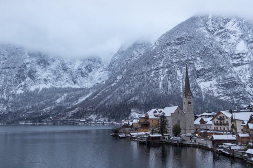 A snow-covered mountain, a church, and a lake. 2