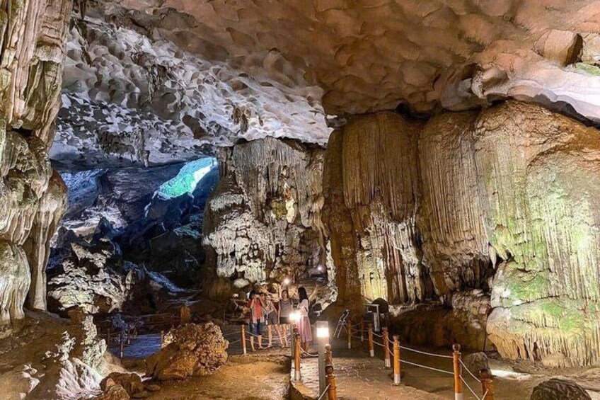 A cave with stalactites and stalagmites, ropes for safety, and visitors. 2