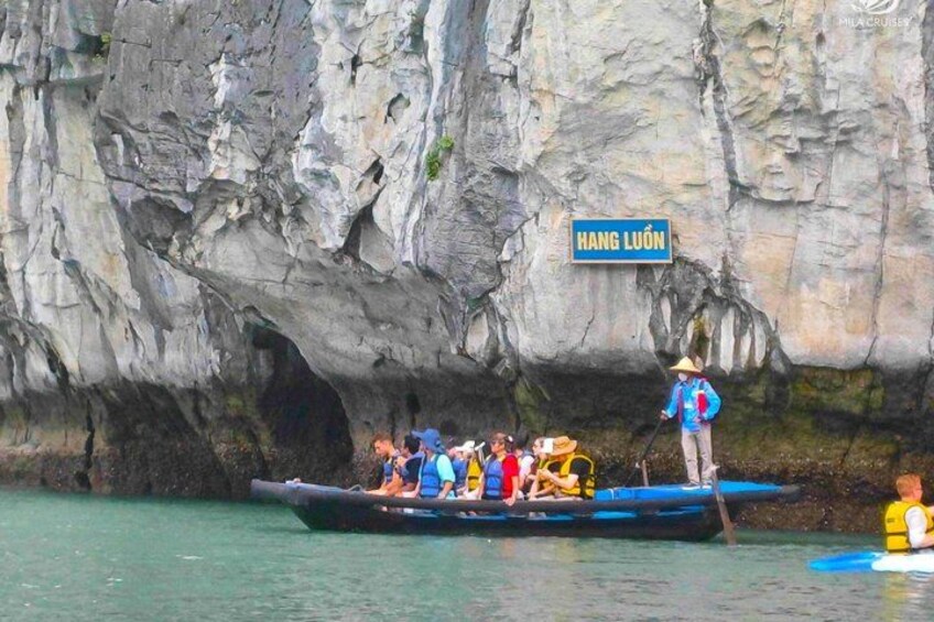 A group of people on a boat near a cave labeled 'HANG LUÔN.' 4