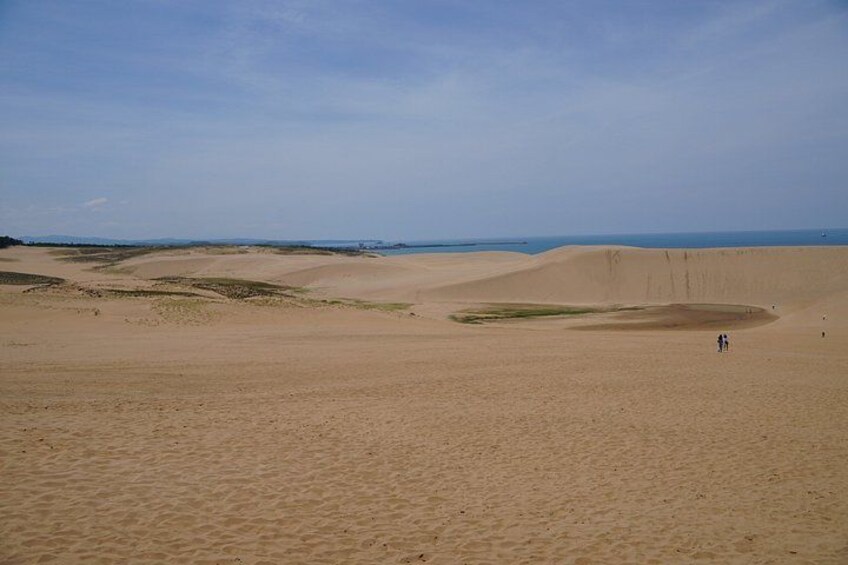 A desert landscape with sand dunes and a clear sky. 4
