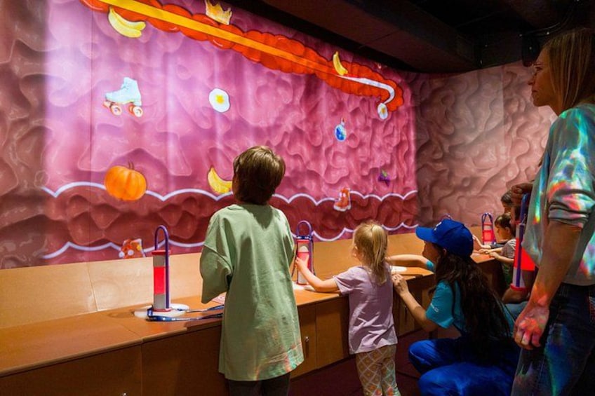 Children playing at a colorful play area with a pink wall and various toys. 4