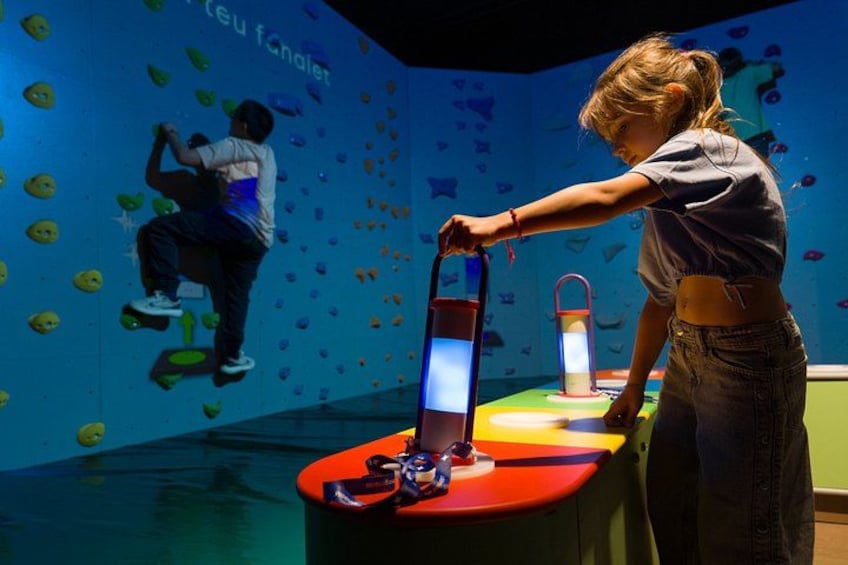 A person interacting with a climbing wall in an indoor setting. 2