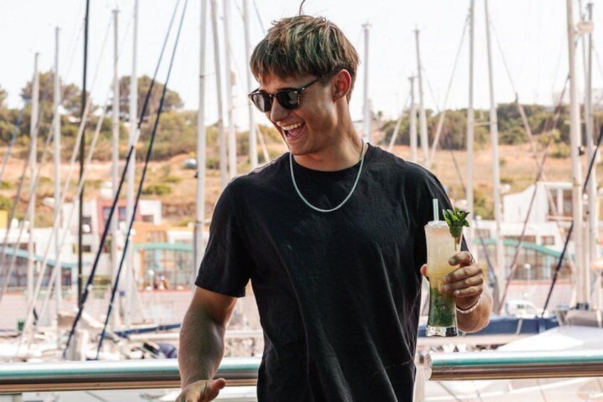 A person on a boat holding a drink. 2