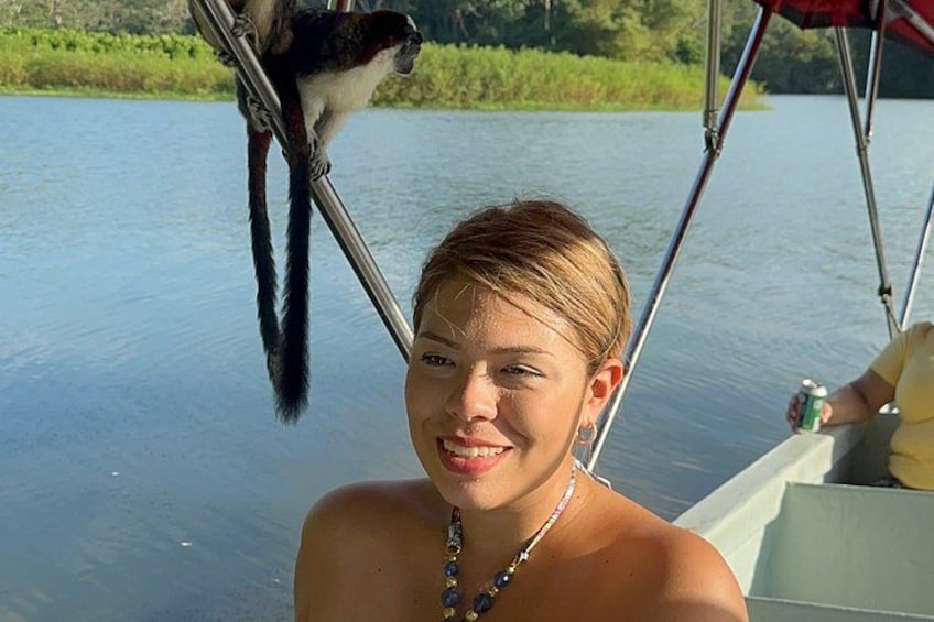 A person on a boat with a monkey on a metal pole. 4
