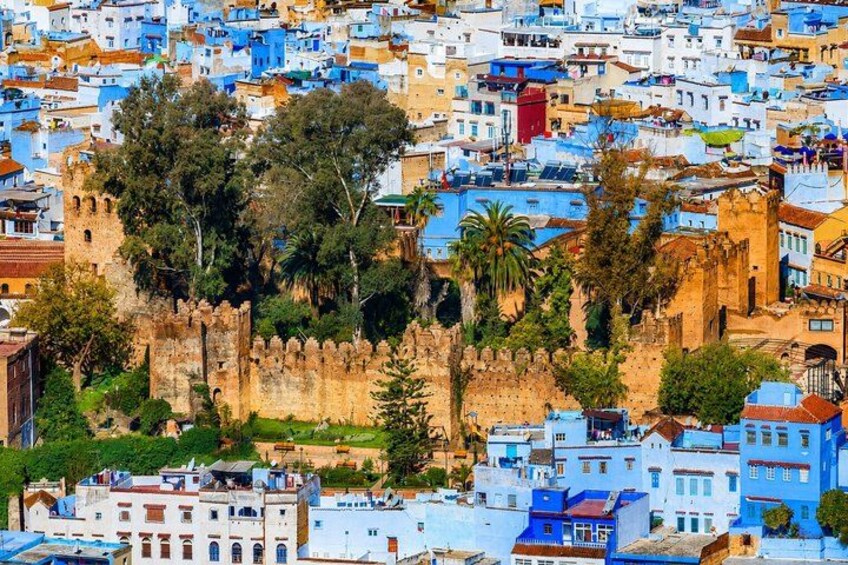 A densely packed urban area with a prominent historical fortification surrounded by colorful buildings. 5