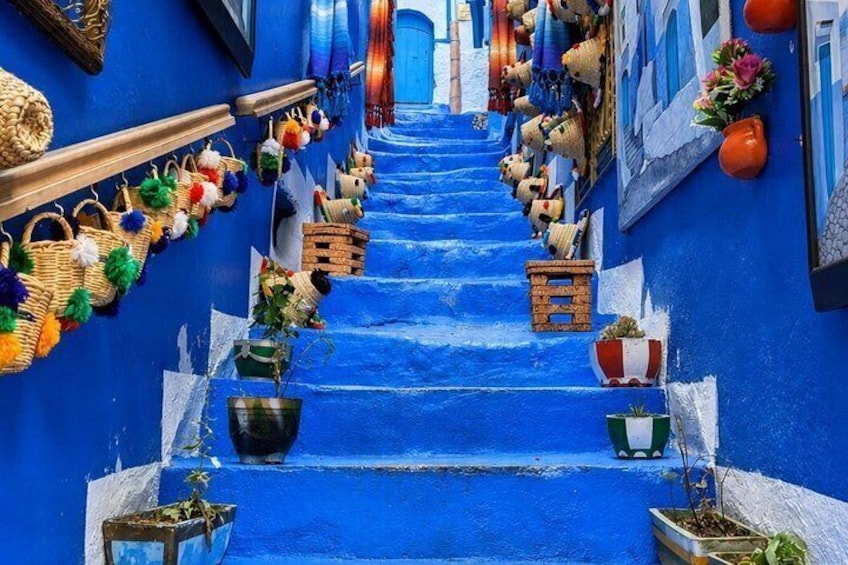A blue-painted stairway with baskets and potted plants. 1