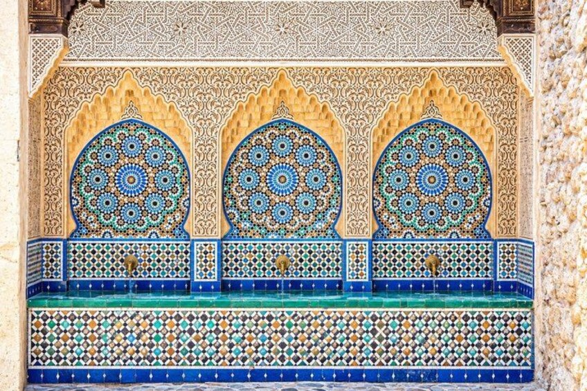 A detailed architectural wall with intricate tile work and arches. 2