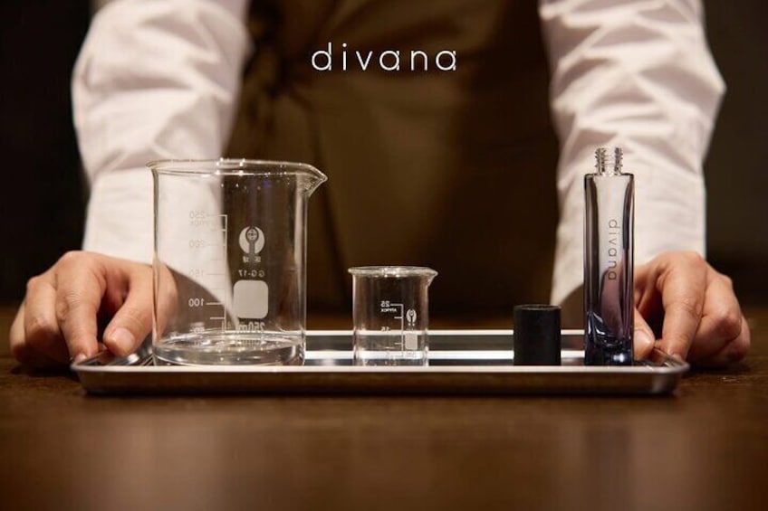 A person handling laboratory glassware, including beakers and a pipette, on a tray. 1
