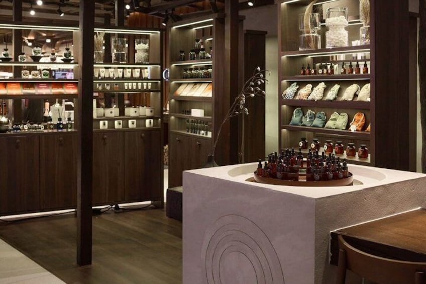 A store interior with wooden shelves, a central display table, and a guitar. 2