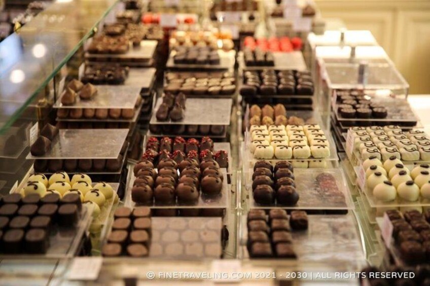 A variety of chocolates displayed in a glass case. 5
