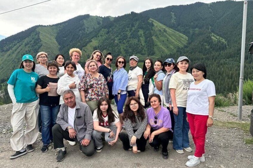 A group of people posing in front of a mountainous landscape. 1