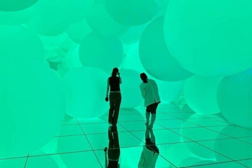 Two people walking in a room with a reflective floor and walls. 5