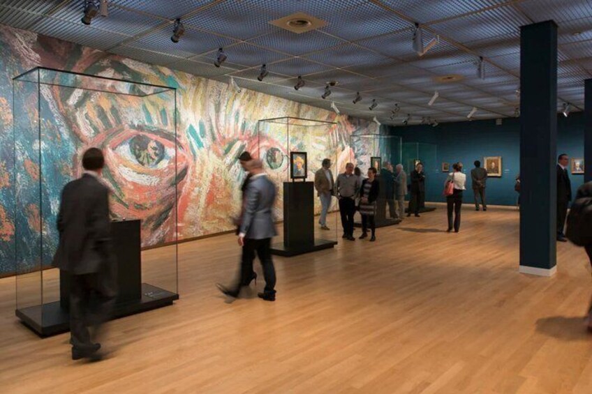 An art gallery with wooden floors and a large abstract painting on the wall. 4