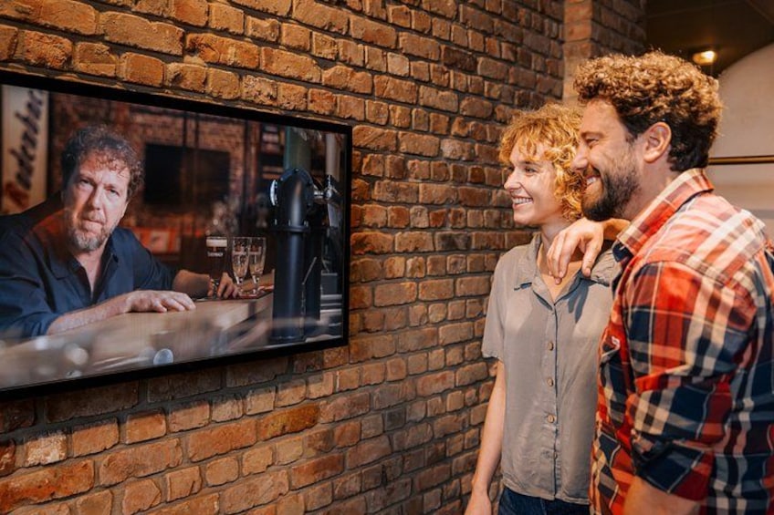 A brick wall with a television displaying a scene. 1