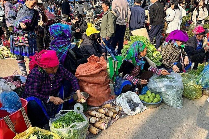 A bustling outdoor market with people selling and buying goods. 1