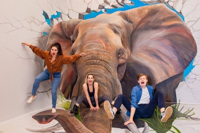 Une fresque représentant un éléphant, avec des personnes posant devant. 3