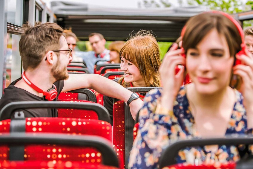 Passengers on a red bus with seats and windows. 5