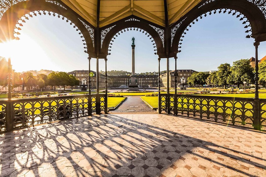 A gazebo with intricate arches, a central monument, and a well-maintained garden with a clear pathway. 2
