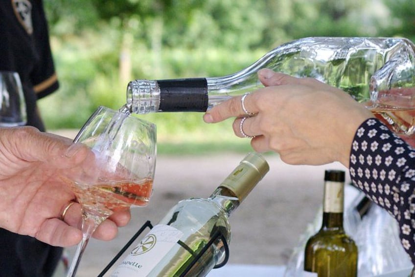 Two people pouring wine into glasses. 1