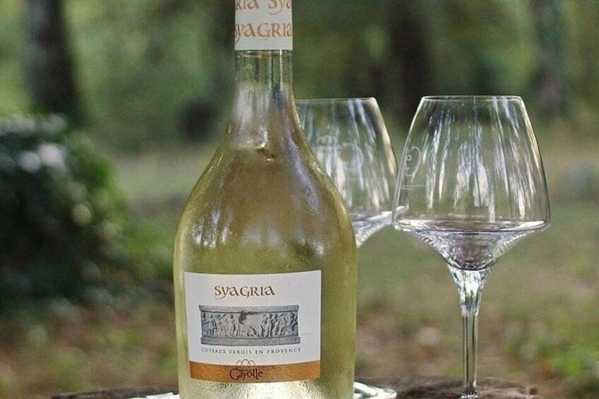 A bottle of Syagria wine with two empty wine glasses. 5