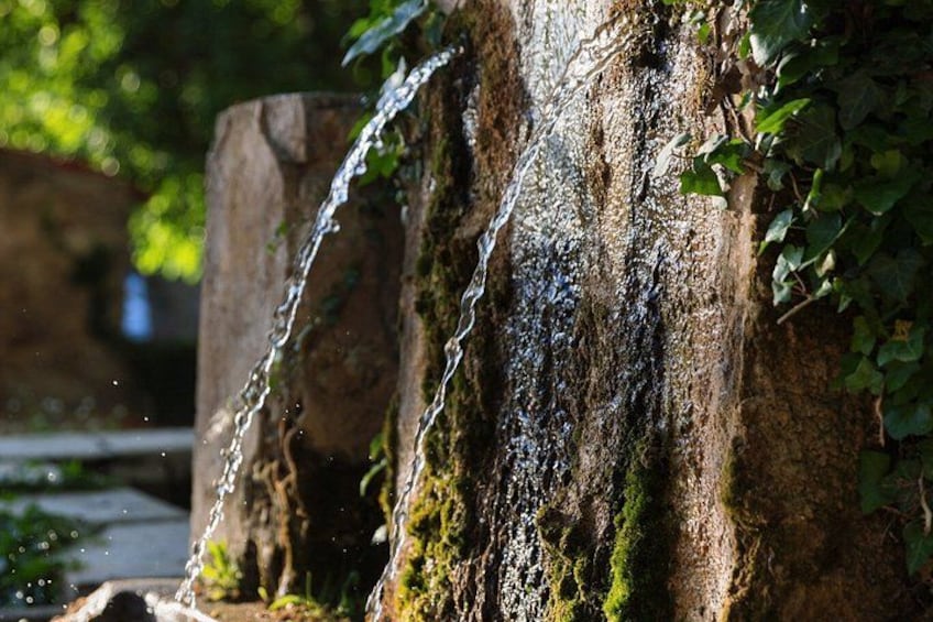 A waterfall cascading over a moss-covered rock surface. 4