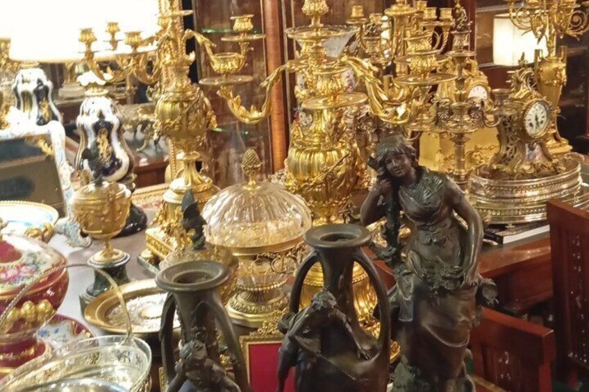 A collection of ornate golden and silver antique items, including statues and decorative objects. 3