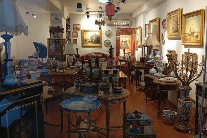 A room filled with antique furniture and decorative items, including tables, chairs, and various vases. 4