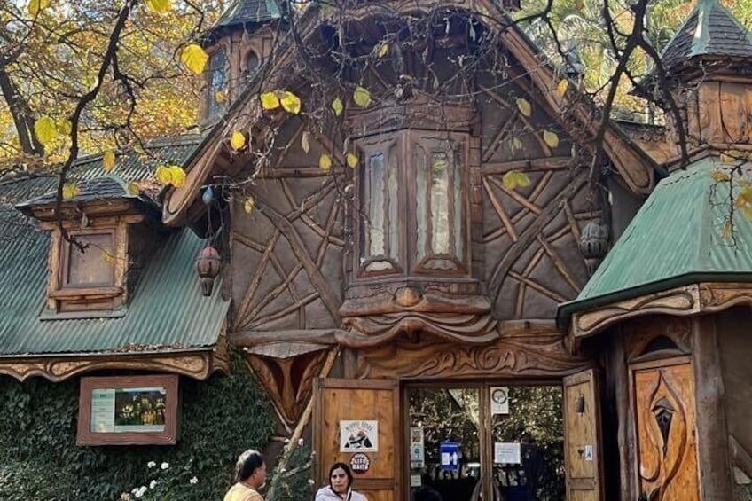 A wooden house with intricate carvings and a green roof. 3