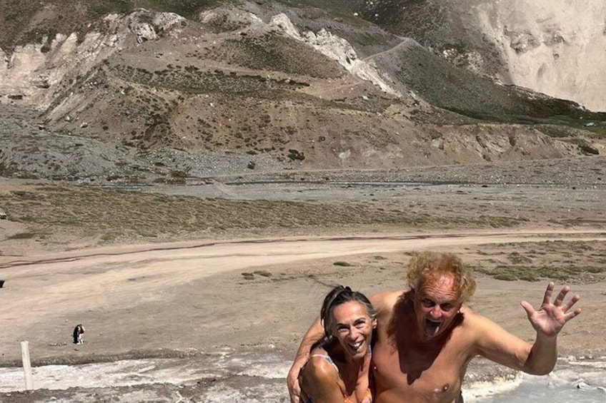 A person carrying another on their back, with a barren landscape and a body of water in the background. 4