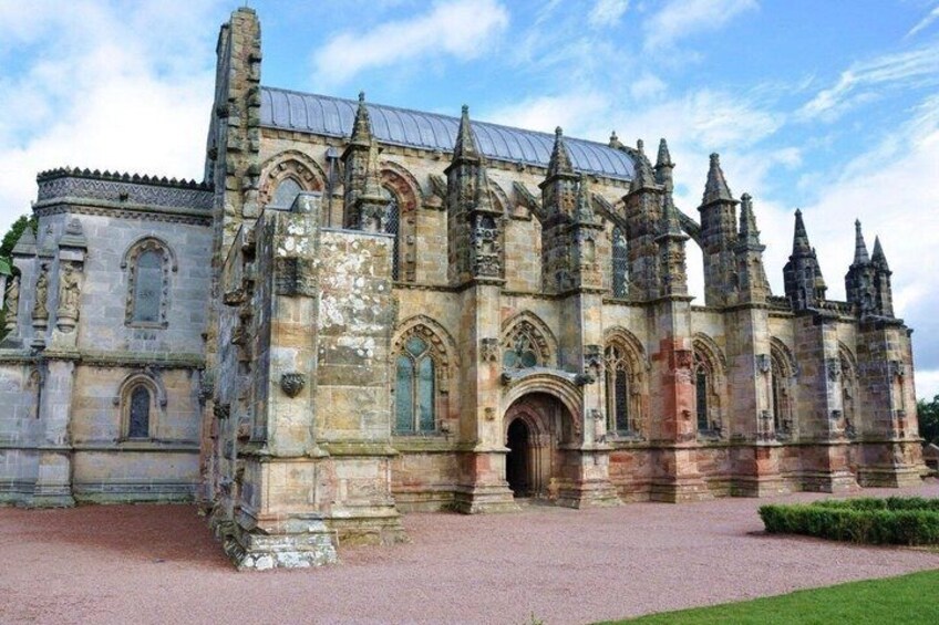 A historic stone building with arched windows and a large entrance. 1