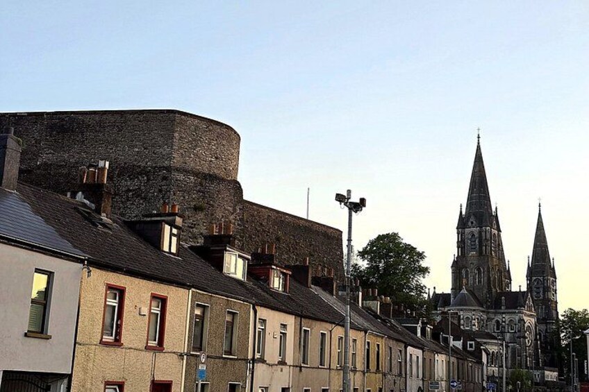 A historic town with medieval architecture, including a church with a tall spire and a round tower. 3