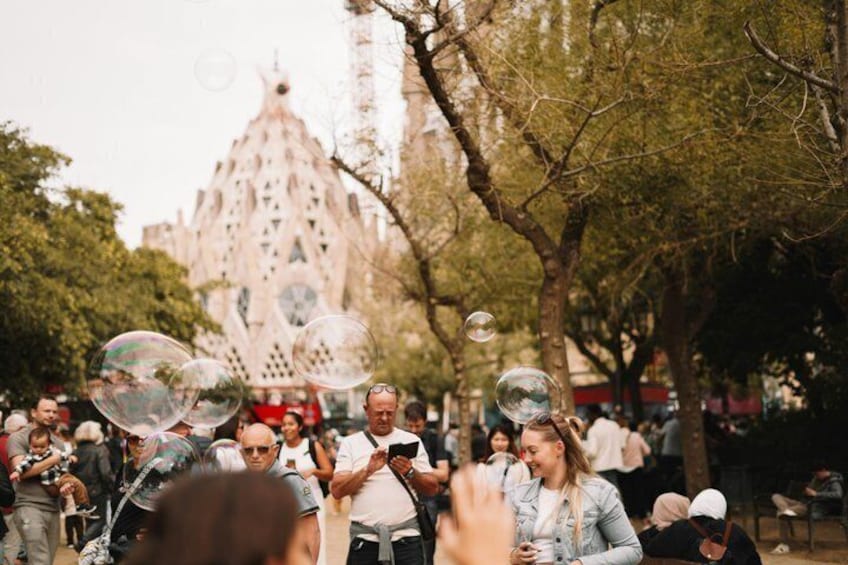 A crowd of people in a park with a large building in the background. 3
