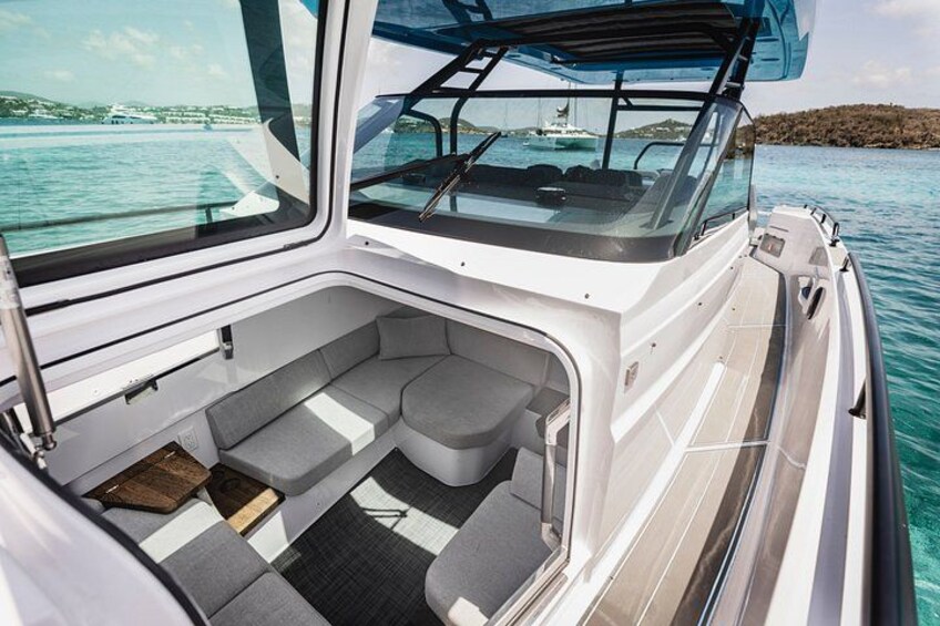 A boat interior with a cushioned seating area and a clear view of the water outside. 4