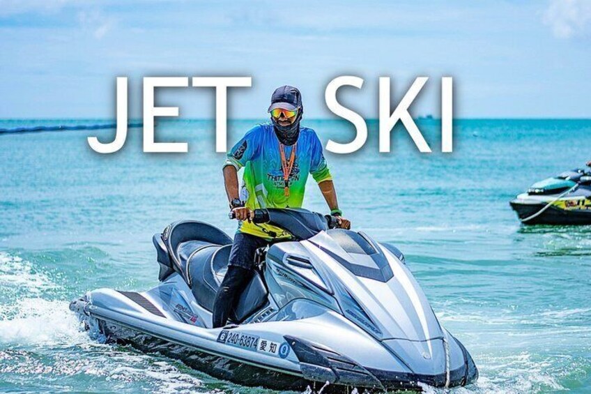 A person jet skiing on clear blue water with a boat in the background. 2