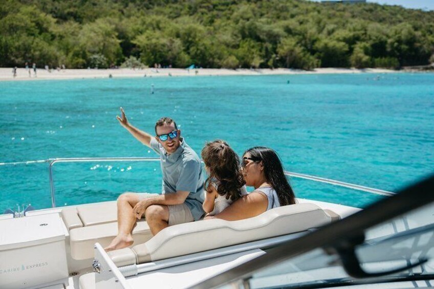 A boat on turquoise water with a beach and greenery in the background. 4