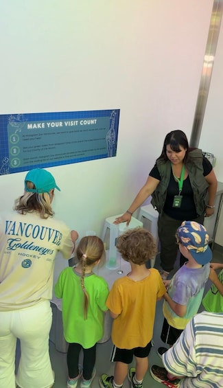 A group of children at a zoo kiosk with a sign instructing them to make their visit count. 2