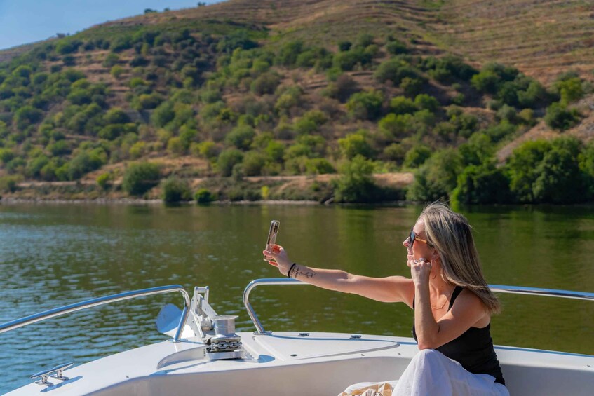 A person on a boat taking a photo with a smartphone. 4