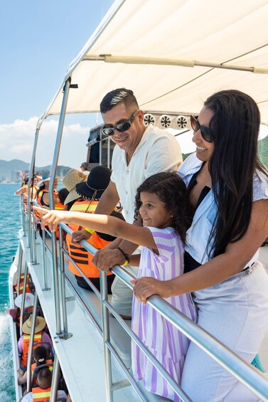 A family on a boat with a clear view of the water and distant mountains. 4