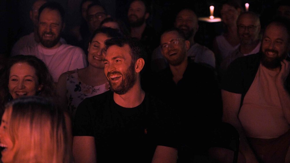 A group of people in a dimly lit indoor setting. 5