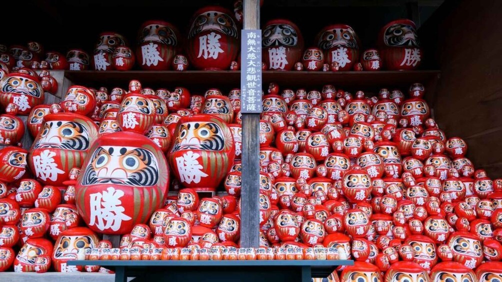 Eine Auswahl an japanischen Puppen in Rot und Weiß, verziert mit chinesischen Schriftzeichen. 5
